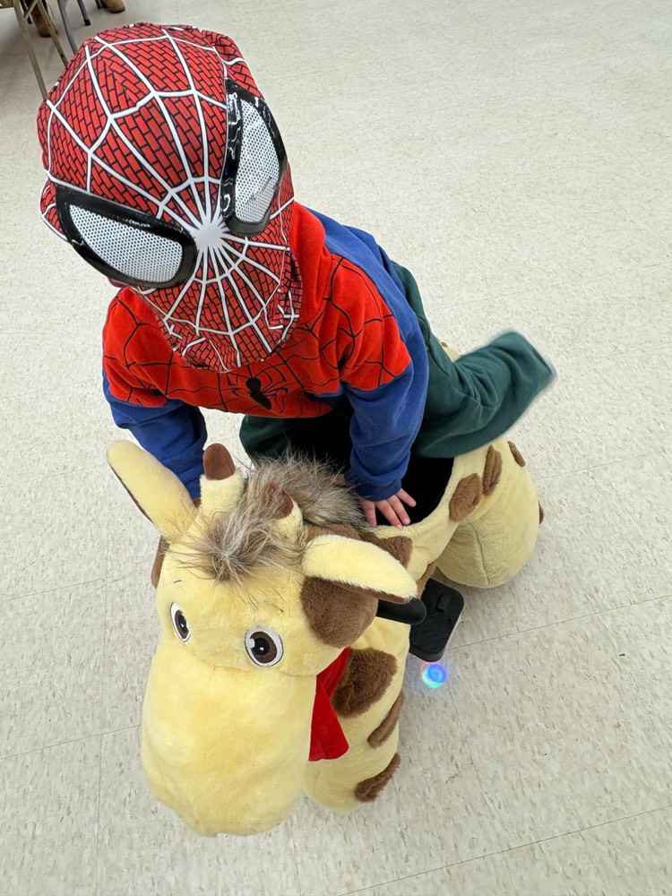Child in costume riding the giraffe