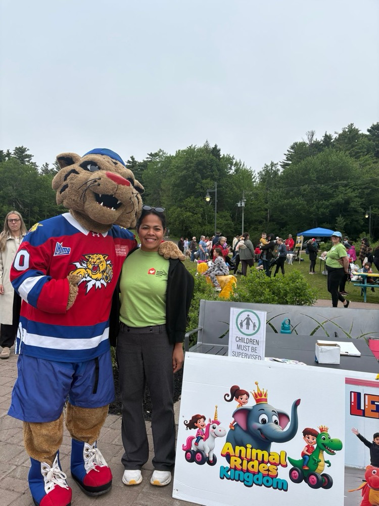 Mascot with the ride-on animals at a community event