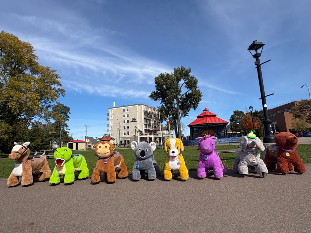 The full herd of ride-on animals lined up in a park
